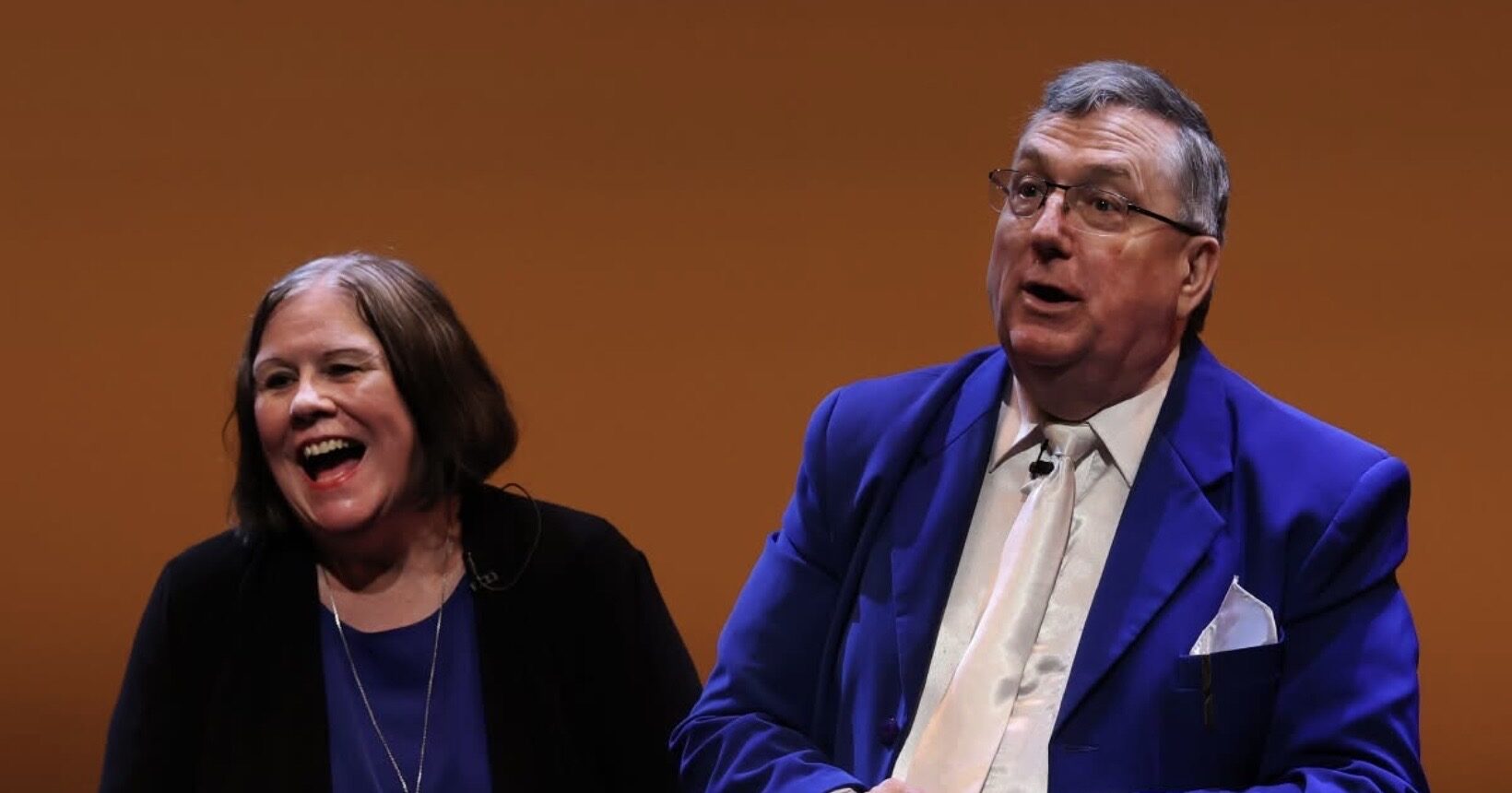 Greg Wood and Oonaugh laughing together during their comedy magic show