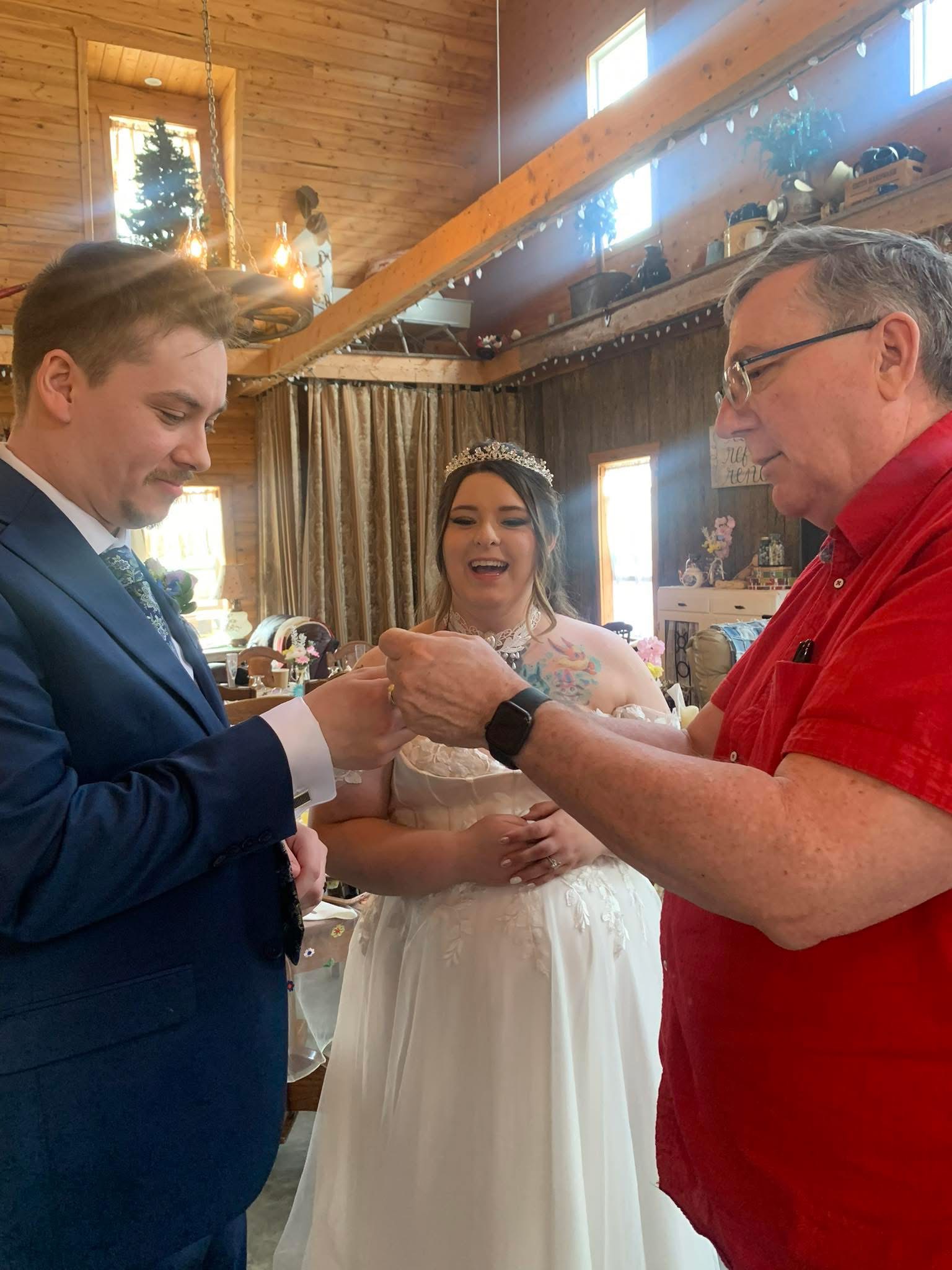 A delighted bride watches Greg Wood perform close-up magic with her groom